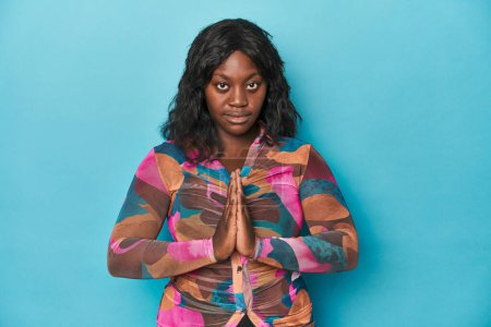 Foto de Joven afroamericana curvilínea mujer rezando, mostrando devoción, persona religiosa buscando inspiración divina. - Imagen libre de derechos