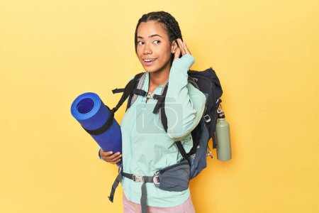 Photo for Indonesian woman ready for mountain trip on yellow trying to listening a gossip. - Royalty Free Image