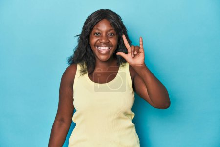 Téléchargez les photos : Jeune femme courbée afro-américaine montrant un geste de cornes comme un concept de révolution. - en image libre de droit