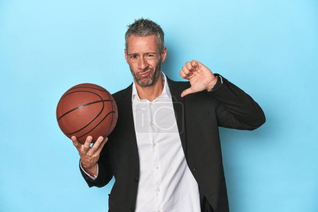Photo for Middle-aged basketball coach on blue backdrop Middle-aged basketball coach on blue backdropfeels proud and self confident, example to follow. - Royalty Free Image