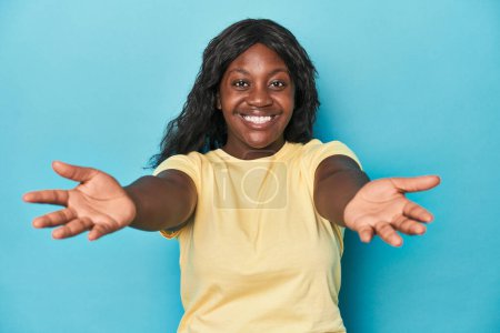 Foto de Joven afroamericana curvilínea mujer mostrando una expresión de bienvenida. - Imagen libre de derechos
