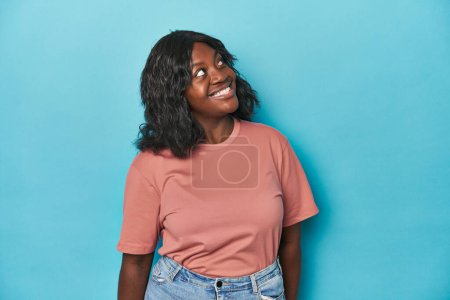 Téléchargez les photos : Jeune femme courbée afro-américaine détendue et heureuse en riant, le cou tendu montrant les dents. - en image libre de droit