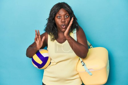 Photo for Young curvy woman with cooler and ball surprised and shocked. - Royalty Free Image