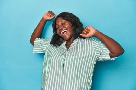 Photo for Young african american curvy woman celebrating a special day, jumps and raise arms with energy. - Royalty Free Image