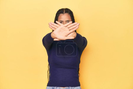 Photo for Young Indonesian woman on yellow studio backdrop doing a denial gesture - Royalty Free Image