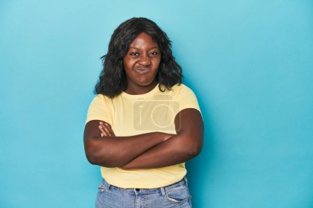 Téléchargez les photos : Jeune femme afro-américaine courbée fronçant les sourcils dans le mécontentement, garde les bras croisés. - en image libre de droit