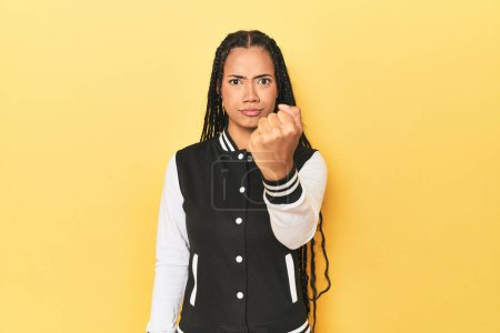 Photo for Indonesian woman in classic black baseball jacket showing fist to camera, aggressive facial expression. - Royalty Free Image