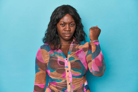Téléchargez les photos : Jeune femme courbée afro-américaine montrant le poing à la caméra, expression faciale agressive. - en image libre de droit