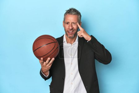 Photo for Middle-aged basketball coach on blue backdrop Middle-aged basketball coach on blue backdropshowing a disappointment gesture with forefinger. - Royalty Free Image