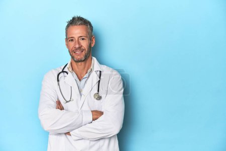 Foto de Caucásico de mediana edad médico masculino en un fondo de estudio azul - Imagen libre de derechos
