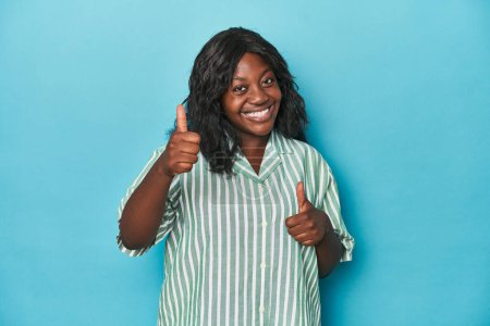 Foto de Joven afroamericana curvilínea mujer levantando ambos pulgares hacia arriba, sonriendo y confiado. - Imagen libre de derechos