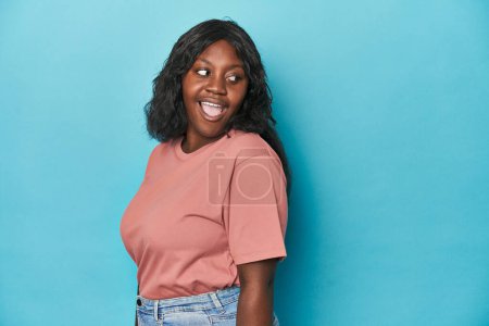 Téléchargez les photos : Jeune femme courbée afro-américaine regarde de côté souriant, gai et agréable. - en image libre de droit