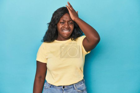 Téléchargez les photos : Jeune femme afro-américaine courbée oubliant quelque chose, frappant le front avec la paume et fermant les yeux. - en image libre de droit