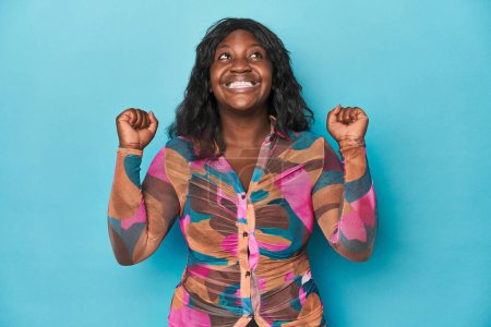 Foto de Joven mujer con curvas afroamericana celebrando una victoria, pasión y entusiasmo, expresión feliz. - Imagen libre de derechos