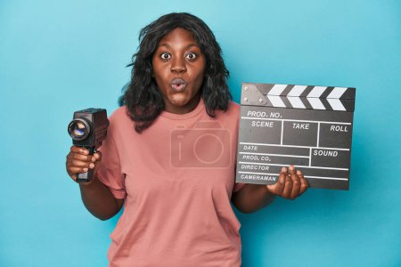 Téléchargez les photos : Femme courbée créative avec caméra de film et clapperboard - en image libre de droit