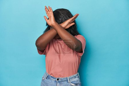 Foto de Joven africana americana curvilínea mujer mantener dos brazos cruzados, concepto de negación. - Imagen libre de derechos