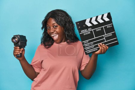 Téléchargez les photos : Femme courbée créative avec caméra de film et clapperboard - en image libre de droit