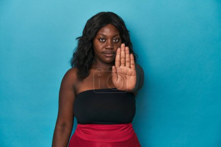 Foto de Joven afroamericana curvilínea mujer de pie con la mano extendida mostrando señal de stop, que le impide. - Imagen libre de derechos