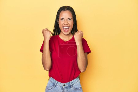 Photo for Young Indonesian woman on yellow studio backdrop cheering carefree and excited. Victory concept. - Royalty Free Image