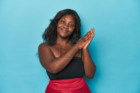 Téléchargez les photos : Jeune femme courbée afro-américaine se sentant énergique et confortable, les mains frottées confiantes. - en image libre de droit