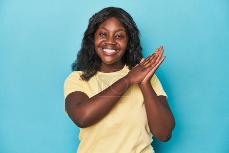 Foto de Joven africana americana curvilínea mujer sentirse enérgico y cómodo, frotándose las manos confiado. - Imagen libre de derechos