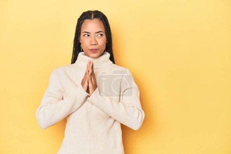 Photo for Young Indonesian woman on yellow studio backdrop making up plan in mind, setting up an idea. - Royalty Free Image