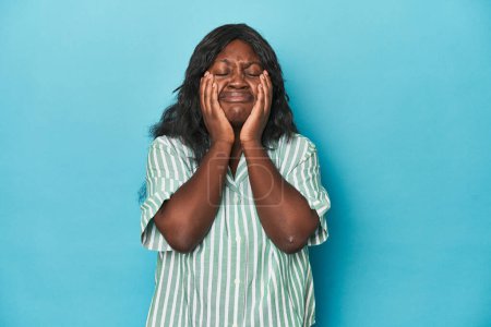 Téléchargez les photos : Jeune femme courbée afro-américaine pleure, malheureuse avec quelque chose, l'agonie et la confusion concept. - en image libre de droit