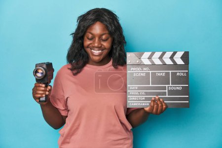 Foto de Mujer con curvas creativas con cámara de película y clapperboard - Imagen libre de derechos