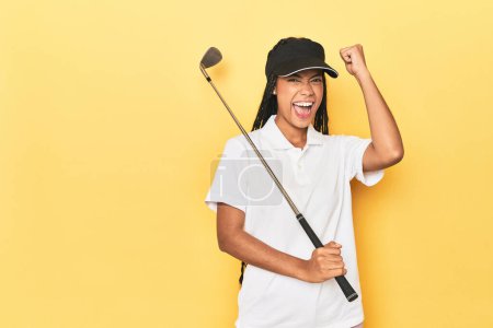 Téléchargez les photos : Golfeuse indonésienne sur fond jaune levant le poing après une victoire, concept gagnant. - en image libre de droit