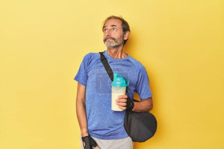 Photo for Gym-goer with protein shake in studio dreaming of achieving goals and purposes - Royalty Free Image