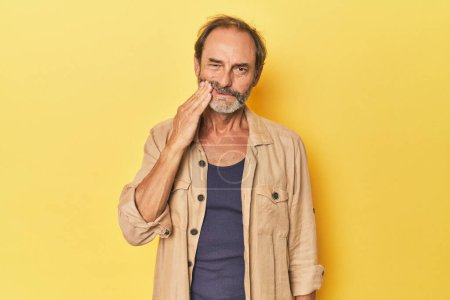 Téléchargez les photos : Homme d'âge moyen caucasien dans un studio jaune ayant une forte douleur aux dents, douleur molaire. - en image libre de droit