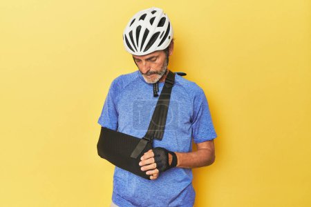 Téléchargez les photos : Cycliste blessé portant fronde semble triste - en image libre de droit
