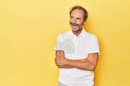 Téléchargez les photos : Blanc homme d'âge moyen en studio jaune souriant confiant avec les bras croisés. - en image libre de droit