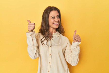 Photo for Portrait of beautiful adult woman raising both thumbs up, smiling and confident. - Royalty Free Image
