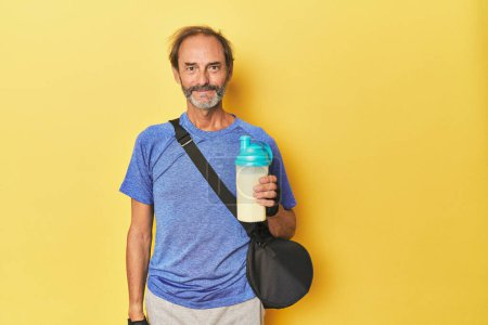 Photo for Sporty man with protein shake and gym bag - Royalty Free Image