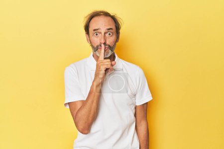 Photo for Caucasian middle-aged man in yellow studio keeping a secret or asking for silence. - Royalty Free Image