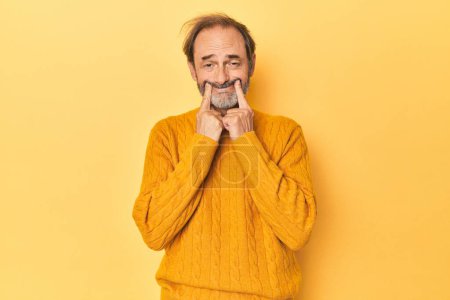 Téléchargez les photos : Caucasien d'âge moyen homme en studio jaune doutant entre deux options. - en image libre de droit