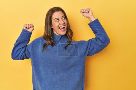 Photo for Portrait of beautiful adult woman raising fist after a victory, winner concept. - Royalty Free Image