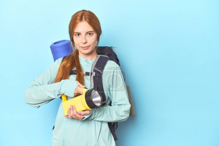 Photo for Redhead mountaineer with backpack and flashlight in studio - Royalty Free Image