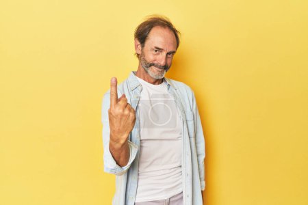 Téléchargez les photos : Caucasien d'âge moyen l'homme dans jaune studio pointant avec doigt à vous comme si inviter venir plus proche. - en image libre de droit