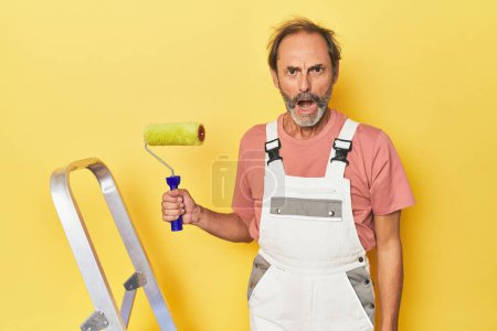 Téléchargez les photos : Homme peinture jaune toile de fond en studio criant très en colère et agressif. - en image libre de droit