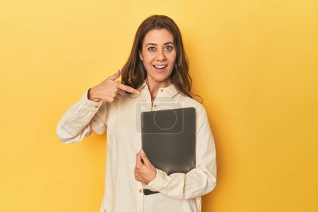 Téléchargez les photos : Portrait de femme adulte pointant à la main vers un espace de copie de chemise, fier et confiant - en image libre de droit