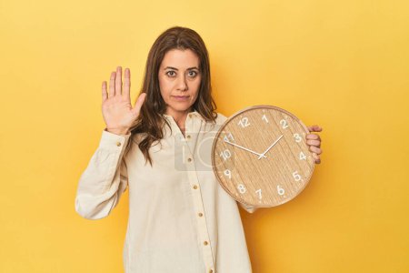 Photo for Portrait of adult woman standing with outstretched hand showing stop sign, preventing you. - Royalty Free Image