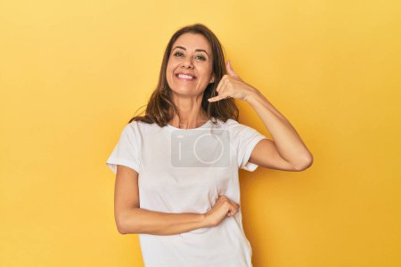 Photo for Portrait of adult woman showing a mobile phone call gesture with fingers. - Royalty Free Image