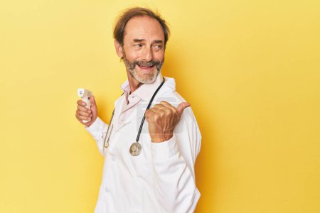 Foto de Doctor sosteniendo termómetro infrarrojo en puntos de estudio con el dedo pulgar lejos, riendo y sin preocupaciones. - Imagen libre de derechos