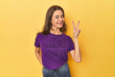 Photo for Portrait of beautiful adult woman showing victory sign and smiling broadly. - Royalty Free Image