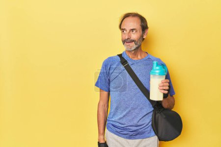Téléchargez les photos : Homme sportif avec boisson protéinée et sac de sport - en image libre de droit