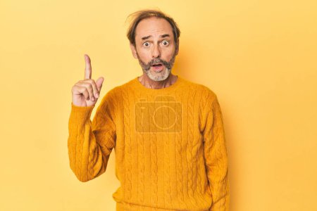 Téléchargez les photos : Blanc homme d'âge moyen en studio jaune ayant une idée, concept d'inspiration. - en image libre de droit