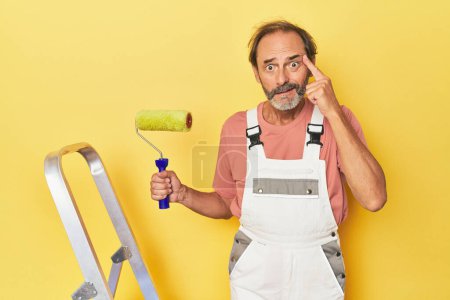 Téléchargez les photos : Homme peignant fond jaune en studio montrant un geste de déception avec index. - en image libre de droit