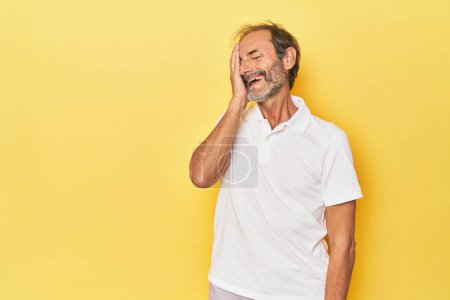 Téléchargez les photos : Blanc homme d'âge moyen en studio jaune riant heureux, insouciant, émotion naturelle. - en image libre de droit